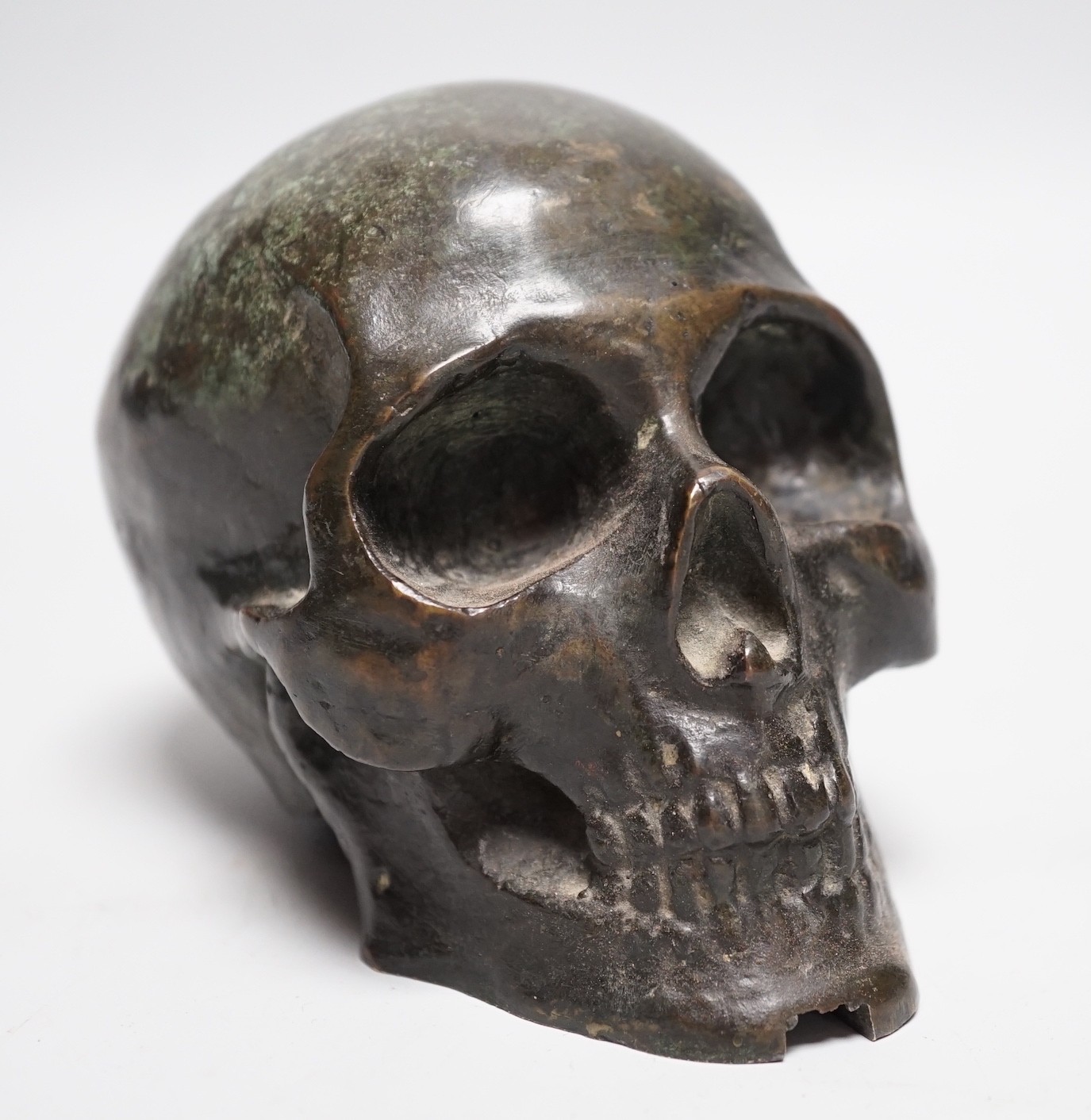 A bronze model of a skull, once part of a larger piece. 13cm deep
